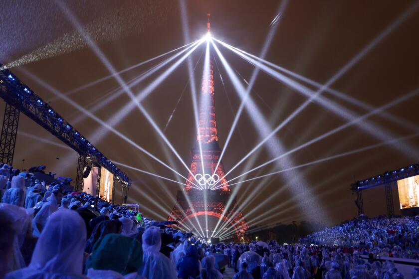 PARIS, FRANCE JULY 26, 2024 - A light show is projected from the Eiffel Tower.