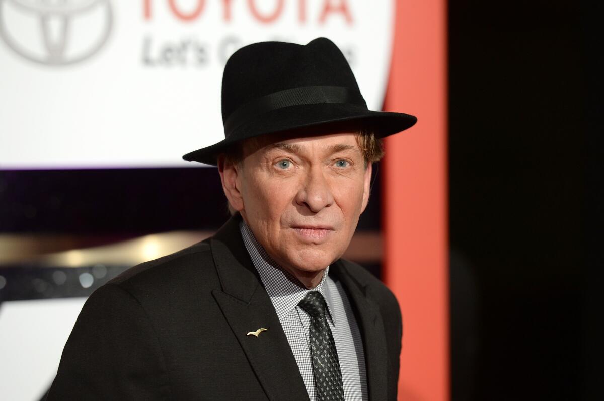 A man in a suit, tie and fedora hat.