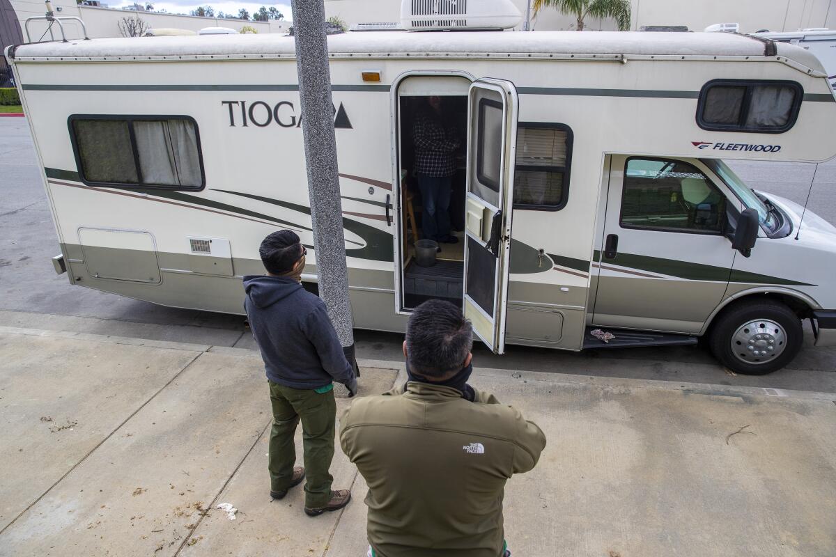 John Cudal, left, and Christian Riehl talk with homeless couple Denise Martin and Kim Eckholdt.