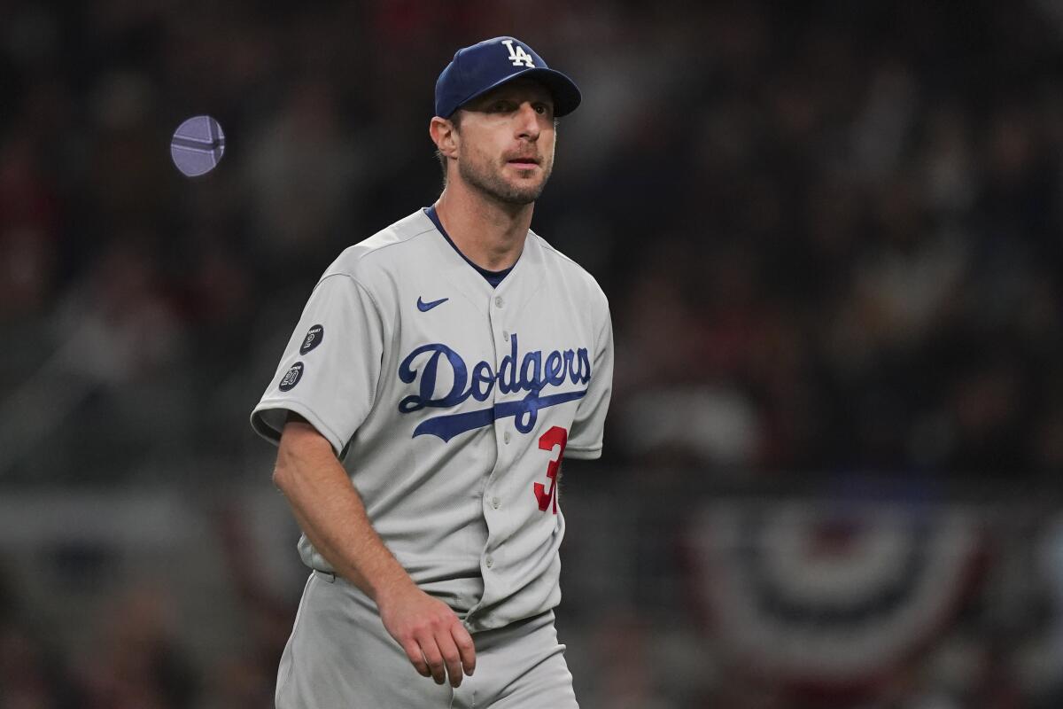 Then-Dodgers starting pitcher Max Scherzer walks off the field during Game 2 of the NLCS against the Atlanta Braves.