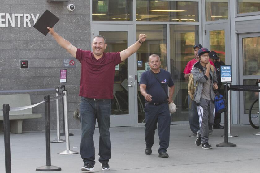 USMC veteran Joaquin Aviles raised his hands as he crossed in to the United States at the PedWest port of entry on August 29, 2019 after being deported in 2000.
