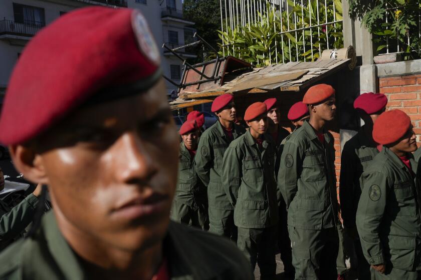 Members of the Presidential Guard line up to vote in a referendum about the future of a disputed territory with Guyana, at a polling station in Caracas, Venezuela, Sunday, Dec. 3, 2023. 3, 2023. (AP Photo/Ariana Cubillos)