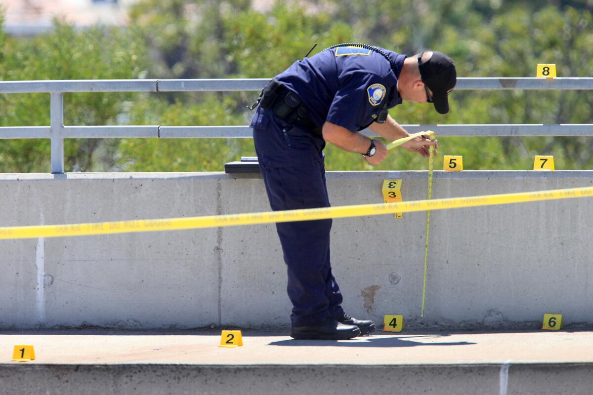 A Newport Beach Police Crime Scene Investigator takes notes along the eastbound side of Pacific Coast Highway, between Bayside Drive and Dover Drive, in Newport Beach on Labor Day. A female body was reported seen below Coast Highway.