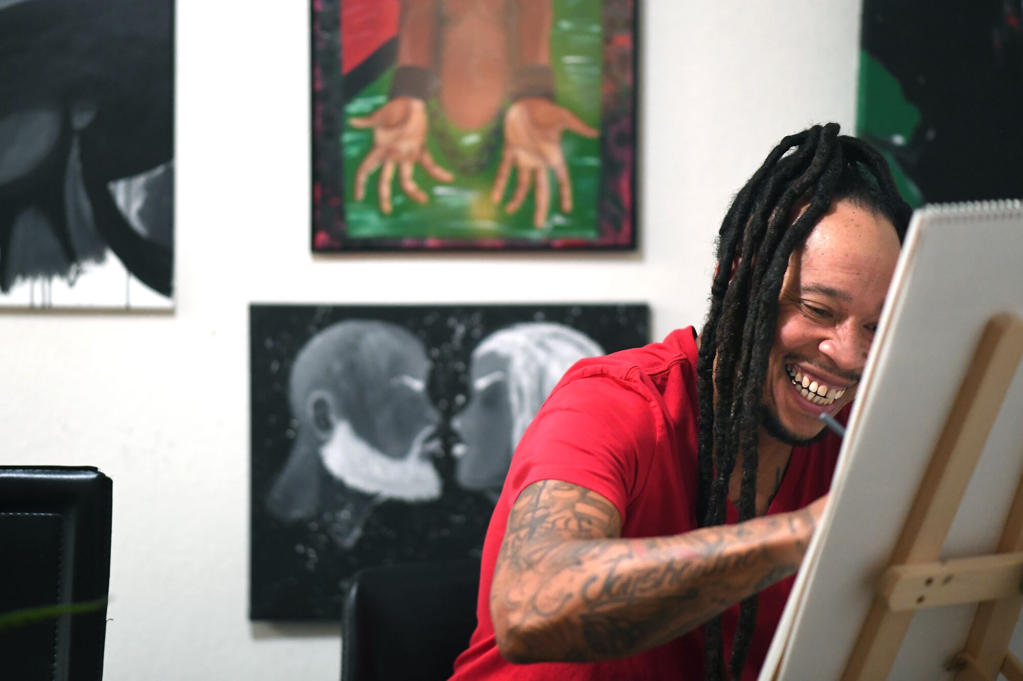 Artist Jason Perry draws in the dining area of his apartment in Riverside.