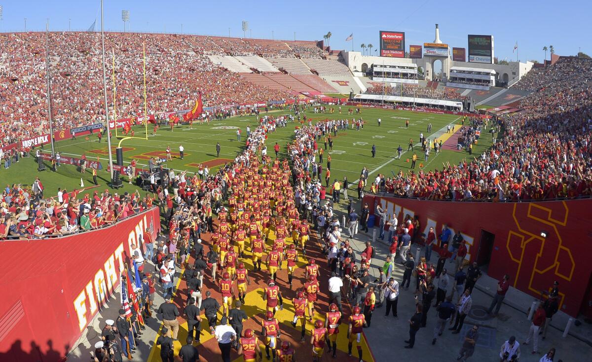 The USC football team takes the field at the Coliseum before the start of a game against Notre Dame on Nov. 29.