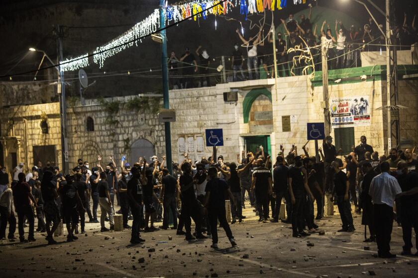 Israeli Arabs gather next to a mosque during clashes between Jews, Israeli police and Arabs, in the mixed town of Lod, central Israel, Wednesday, May 12, 2021. As rockets from Gaza streaked overhead, Arabs and Jews fought each other on the streets below. Rioters torched vehicles, a restaurant and a synagogue in one of the worst spasms of communal violence that Israel has seen in years. (AP Photo/Heidi Levine)