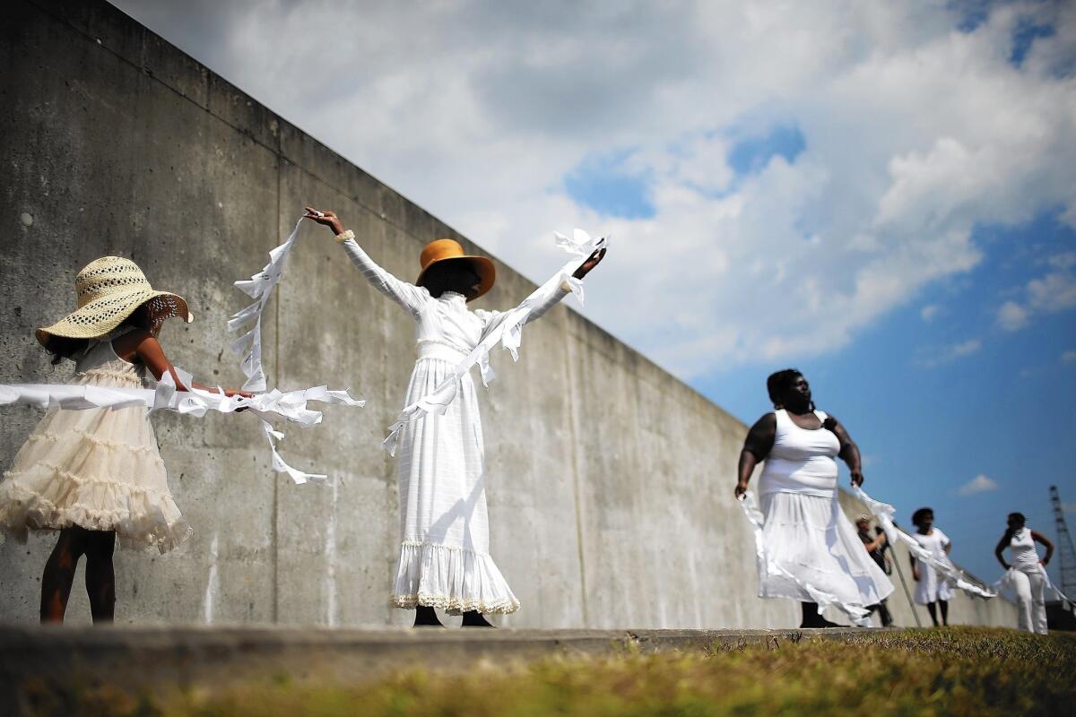 Performers dance along the repaired levee wall in New Orleans' Lower 9th Ward during a ceremony marking the 10th anniversary of Hurricane Katrina.