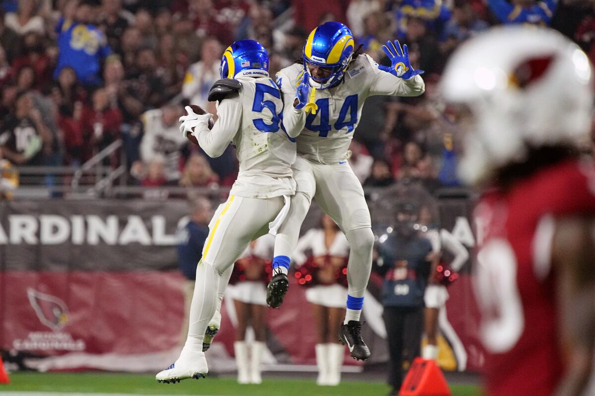 Rams linebacker Ernest Jones celebrates his red-zone interception against the  Cardinals with teammate Jamir Jones (44).