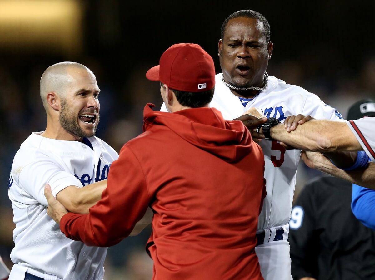 Dodgers infielders Skip Schumaker, left, and Juan Uribe are restrained by Arizona Diamondbacks pitching coach Charles Nagy during a seventh inning benches clearing brawl at Dodger Stadium on June 11.
