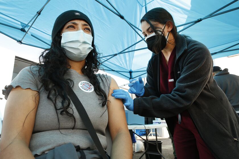 Elizabeth Raygoza gets her Pfizer vaccine shot from Physician Assistant-Certified Alyssa Hernandez 