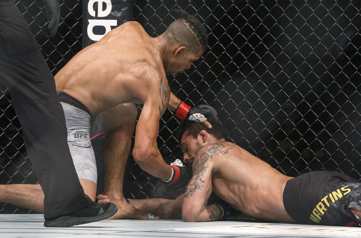 Kajan Johnson, left, finishes off Adriano Martins during their bout at UFC 215.