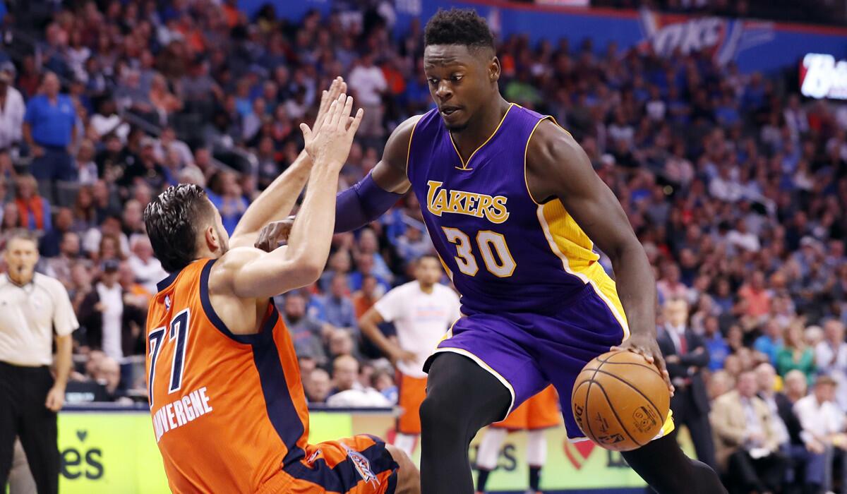 Lakers forward Julius Randle drives to the basket around Oklahoma City Thunder center Joffrey Lauvergne during the first half Sunday.