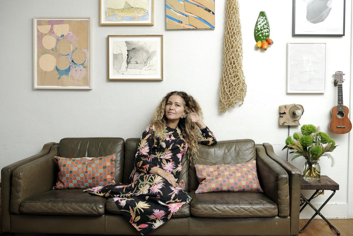 Designer Beatrice Valenzuela sits on a brown leather couch in her Echo Park studio.