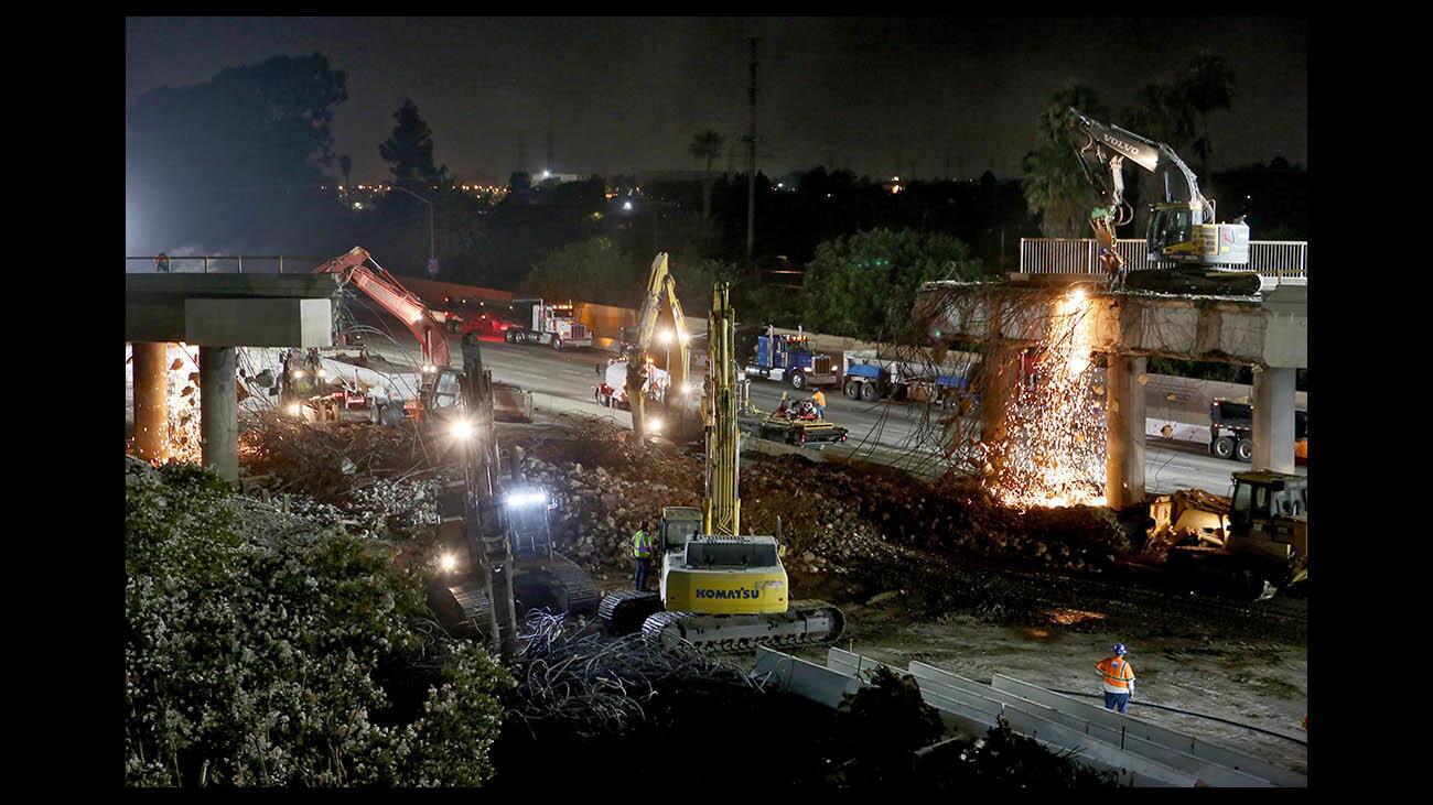 Construction crews demolish the McFadden Avenue bridge over the southbound lanes of the 405 Freeway early Sunday in Huntington Beach. The other side of the bridge will be demolished next weekend.