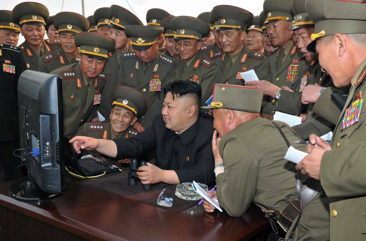 North Korean leader Kim Jong Un, center, is shown at a defense facility computer in this photo released in April. Only the political elite and high-ranking military have access to the Internet in North Korea.