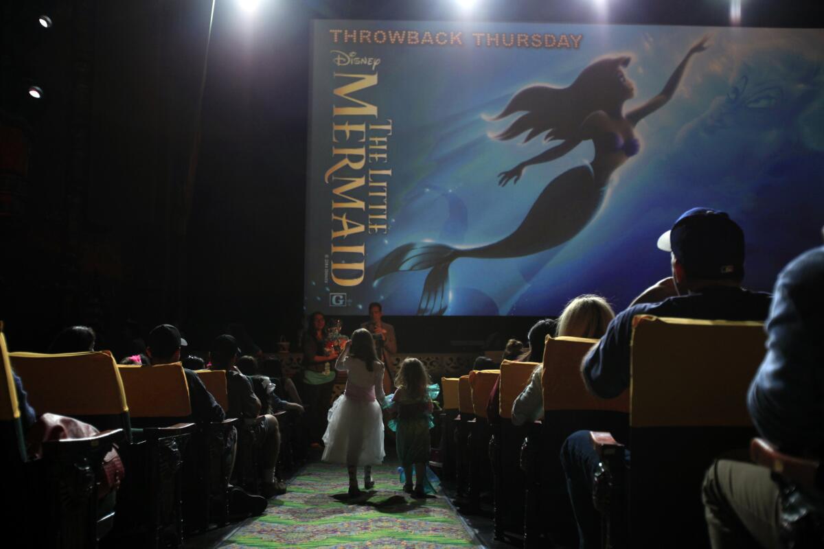 Costumed audience members are called to the stage at the El Capitan during a "Throwback Thursday" screening of "Little Mermaid" on June 30, 2014. (Francine Orr/ Los Angeles Times)