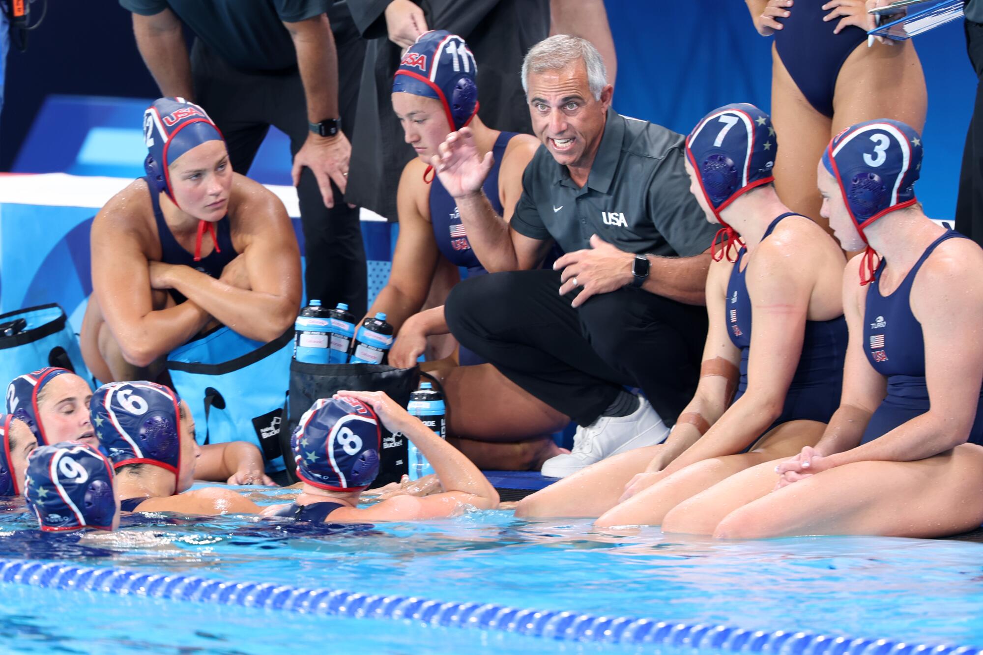 U.S. women's water polo coach Adam Krikorian speaks to his players during a timeout against Greece.