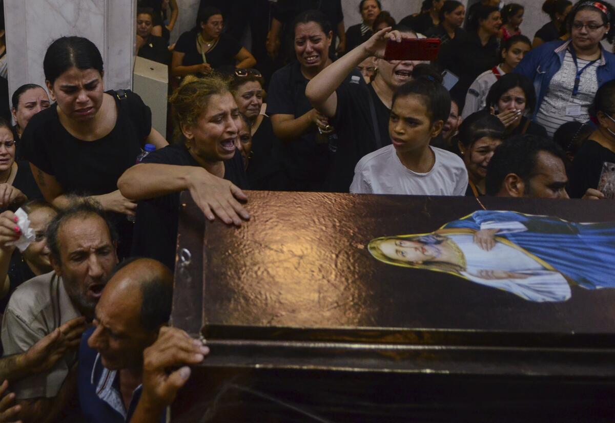 Mourners attend a memorial service for victims of a fire at a church in Greater Cairo that killed dozens on Sunday, Aug. 14, 2022. The blaze ignited at the Abu Sefein church in the densely populated neighborhood of Imbaba while a service was underway, according to the church. (AP Photo/Tarek Wajeh)