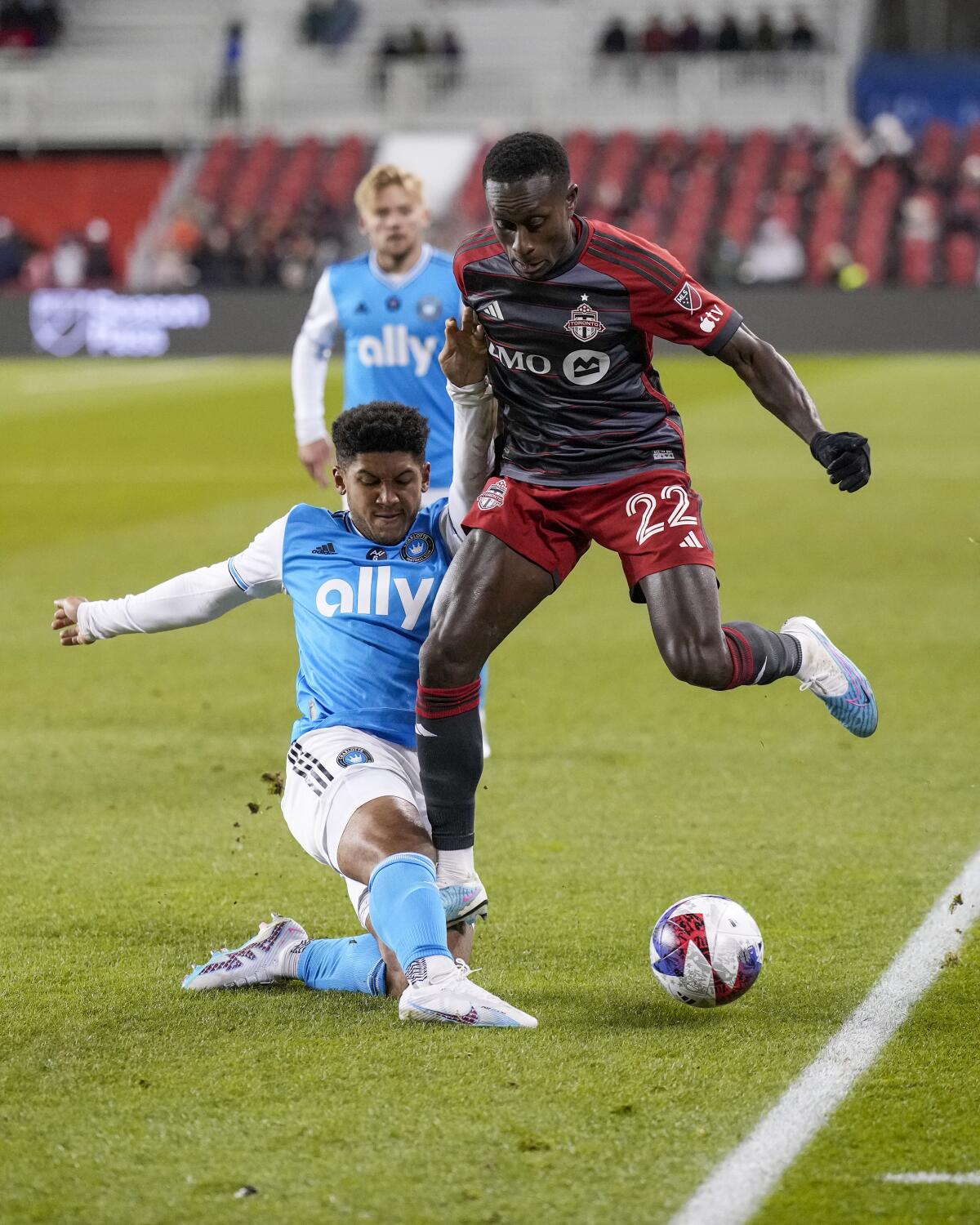 Charlotte FC defender Jaylin Lindsey, front left, clears the ball as Toronto FC midfielder Richie Laryea (22) battles during first-half MLS soccer match action in Toronto, Saturday, April 1, 2023. (Andrew Lahodynskyj/The Canadian Press via AP)