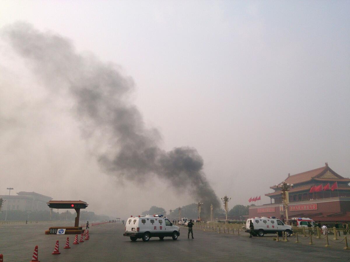 Police cars block off the roads leading into Tiananmen Square as smoke rises where a vehicle exploded in front of Tiananmen Gate in Beijing on Oct. 28, 2013, in what authorities said was a terrorist attack.