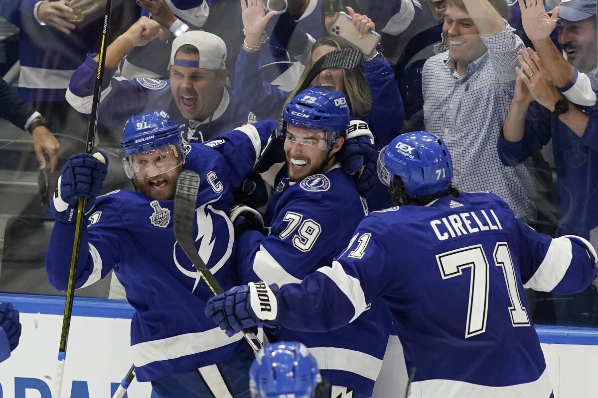 Tampa Bay Lightning center Steven Stamkos and center Anthony Cirelli crowd left wing Ross Colton after scoring.
