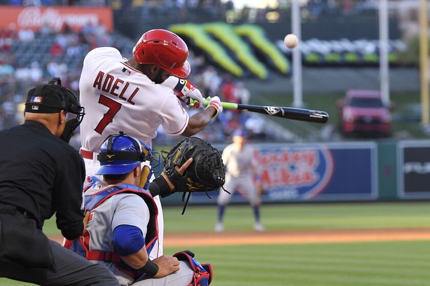 Los Angeles Angels' Jo Adell, right, hits a solo home run as Chicago Cubs catcher Yan Gomes, center, watches along with home plate umpire Vic Carapazza during the second inning of a baseball game Thursday, June 8, 2023, in Anaheim, Calif. (AP Photo/Mark J. Terrill)