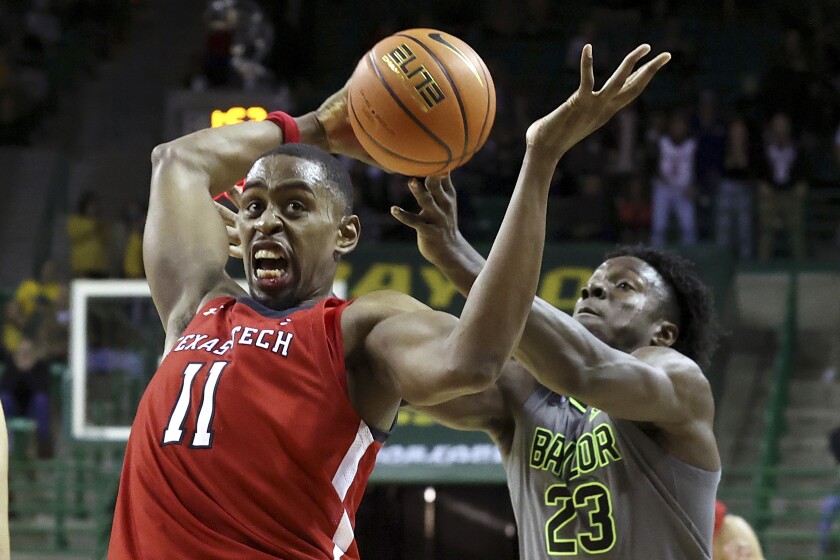 CORRECTS ID TO BAYLOR FORWARD JONATHAN TCHAMWA TCHATCHOUA, RIGHT - Texas Tech forward Bryson Williams, left,, grabs a loose ball from Baylor forward Jonathan Tchamwa Tchatchoua during the second half of an NCAA college basketball game Tuesday, Jan. 11, 2022, in Waco, Texas. (AP Photo/Jerry Larson)