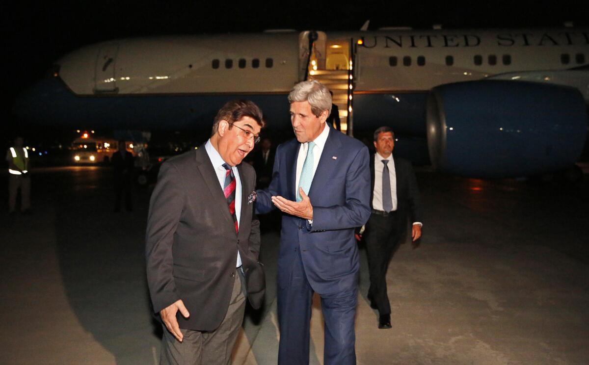 U.S. Secretary of State John F. Kerry talks with the Afghan Foreign Ministry's chief of protocol, Ambassador Hamid Siddiq, upon arrival at Kabul International Airport.