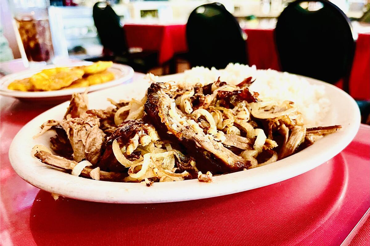 Pierna de puerco with a side of tostones at the Cuban restaurant El Colmao in Los Angeles.