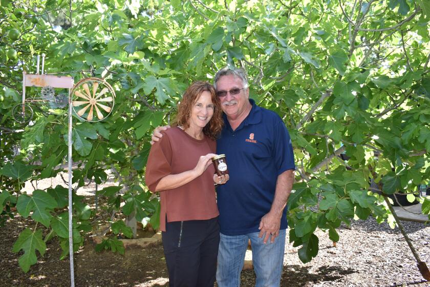 Michele and Larry Krupinski in front of their original two black mission fig trees at their Rancho Bernardo home.