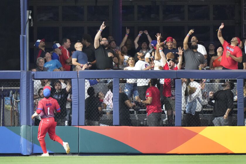 Cuba outfielder Roel Santos (1) watches as a ball hit by U.S.'s Trea Turner goes into the stands for a home run during the second inning of a World Baseball Classic game, Sunday, March 19, 2023, in Miami. (AP Photo/Wilfredo Lee)