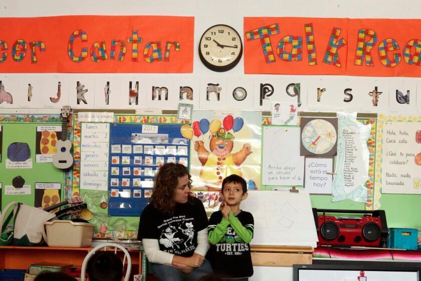 LOS ANGELES, CA - JANUARY 26, 2016 -- Teacher Hillary Erlich, center, background, with Noah Rodriguez, 4, teaches Pre-K students in a Spanish Immersion ETK (Expanded Transitional Kindergarten) class at the Grand View Elementary School in Los Angeles on January 26, 2017. Daisy Hernandez, foreground, walks by. The sign in the background says, Hablar, Leer, Cantar, Talk, Read, Sing. (Genaro Molina / Los Angeles Times)