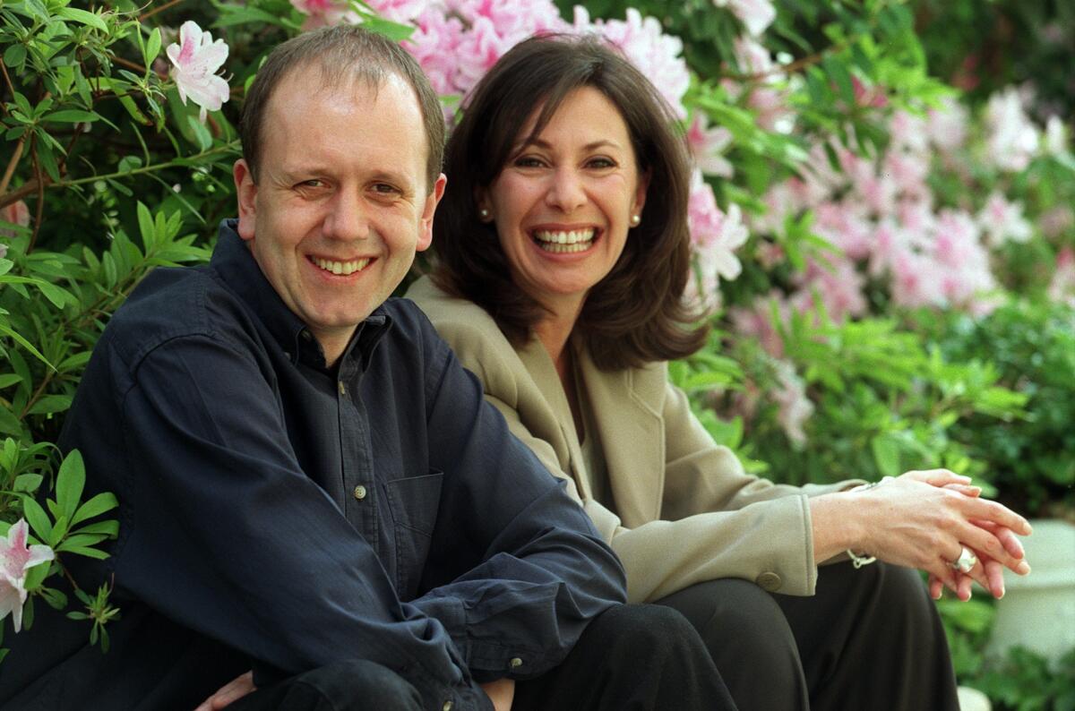  Producer David Parfitt sits by a flowerbed with his "Shakespeare in Love" coproducer Donna Gigliotti.