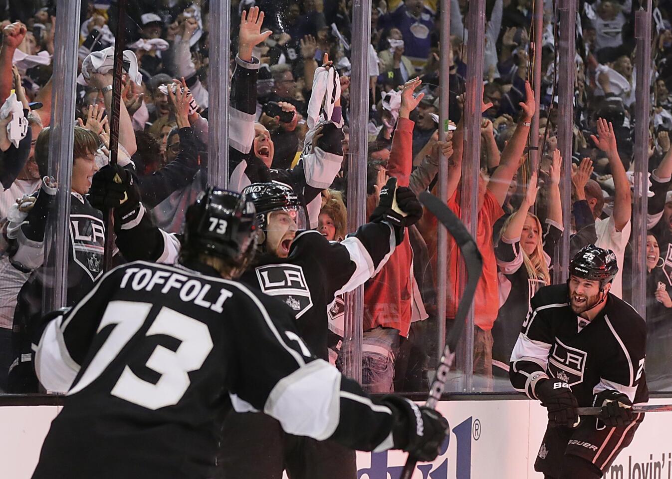 Kings center Trevor Lewis is about to be joined in celebration by teammates Tyler Toffoli and Dustin Penner after scoring the eventual winning goal against the Sharks in the third period of Game 2 on Thursday night at Staples Center.