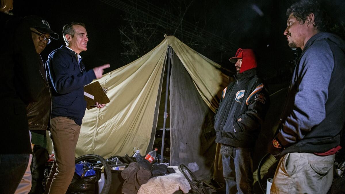 Los Angeles Mayor Eric Garcetti, joined by L.A. County Supervisor Mark Ridley-Thomas, left, talks with Manny Munoz and Ricardo Seleuco as they meet with and count homeless people during the first day of the Greater Los Angeles Homeless Count in January.