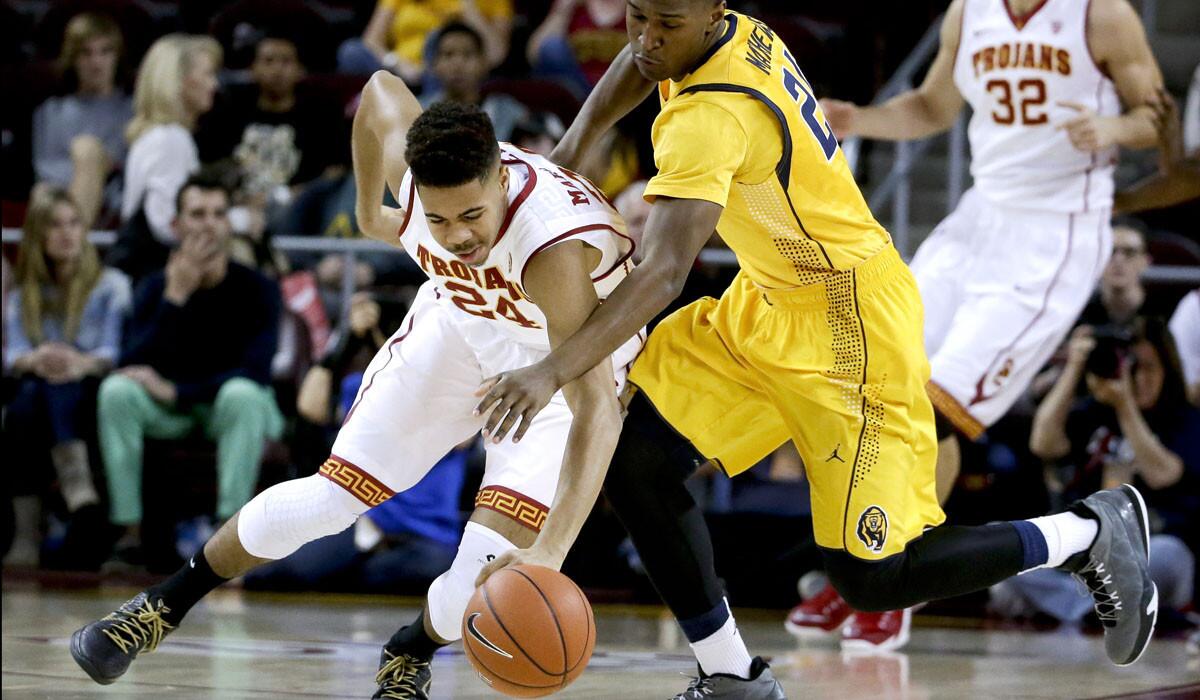 USC guard Malik Marquetti (24) and California guard Jordan Mathews chase after a loose ball during the first half of their game Wednesday at Galen Center.