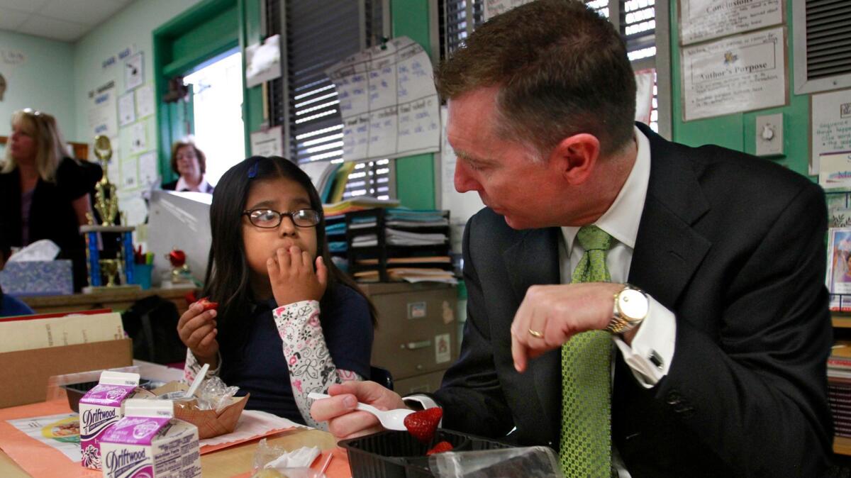 Former L.A. Unified schools Supt. John Deasy, right, helped push through a ban on flavored milk, which is being offered again.