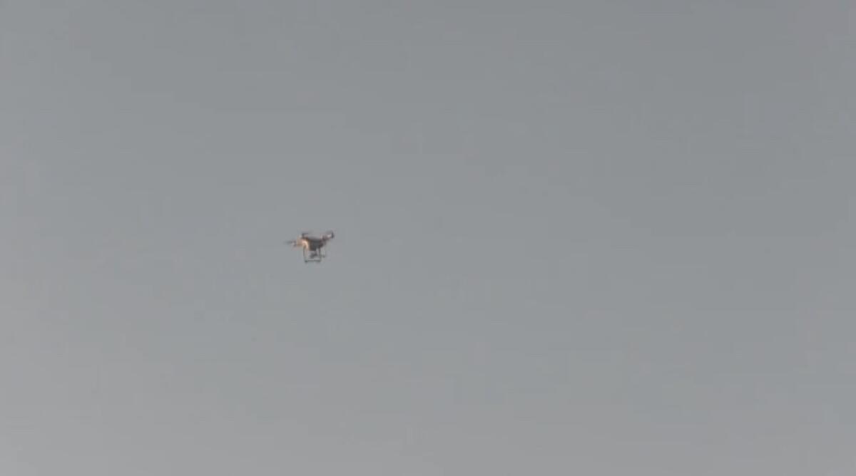 A drone over a football game in 2016. Drones are used to film practices.