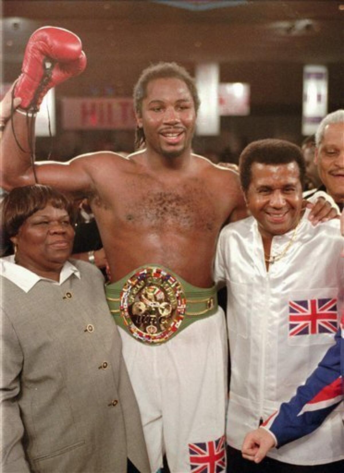 File-This Feb. 7, 1997 file photo shows newly crowned WBC heavyweight champion Lennox Lewis, center, reacting with his mother, left, and trainer Emanuel Steward after defeating Oliver McCall with a TKO in the fifth round at the Hilton Hotel in Las Vegas. teward, the owner of the legendary Kronk Gym and one of boxing's greatest trainers, has died. He was 68. Victoria Kirton, Steward's executive assistant, says Steward died Thursday Oct. 25, 2012 in a Chicago hospital. She did not disclose the cause of death. (AP Photo/Jeff Scheid, File)