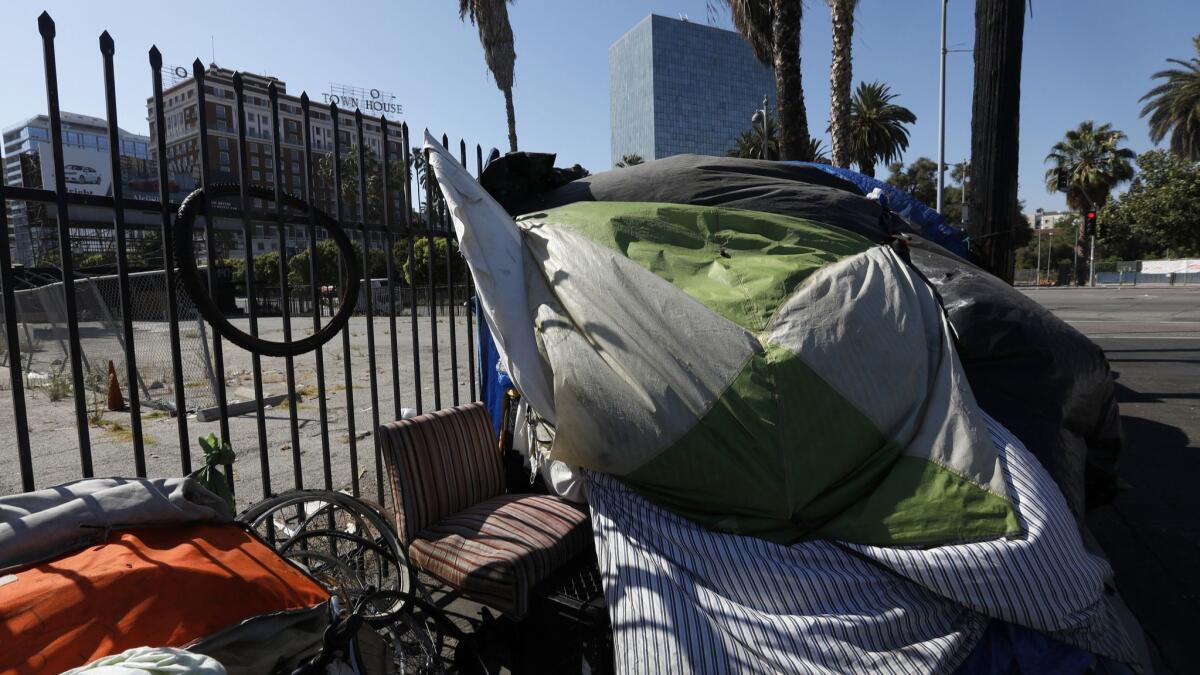 Tents line the sidewalk across the street from Lafayette Park near the corner of Hoover Street and Wilshire Boulevard in Los Angeles.