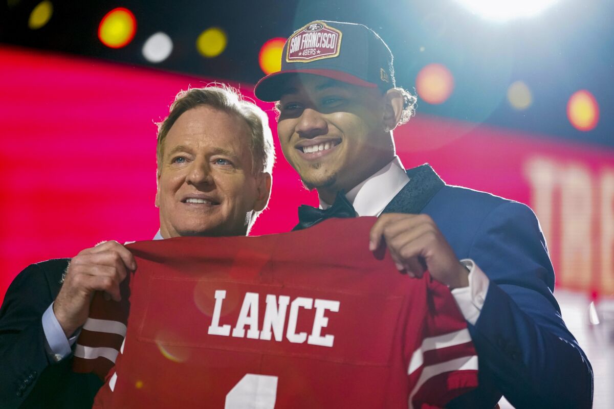 North Dakota State quarterback Trey Lance, right, holds a jersey with NFL Commissioner Roger Goodell after being chosen by the San Francisco 49ers with the third pick in the first round of the NFL football draft Thursday April 29, 2021, in Cleveland. (AP Photo/Tony Dejak)