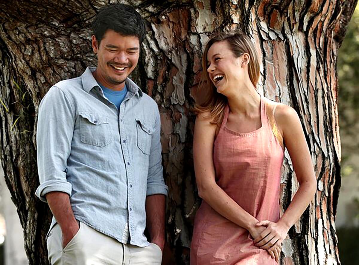 "Short Term 12" writer-director Destin Daniel Cretton and actor Brie Larson smiling and standing in front of a big tree.