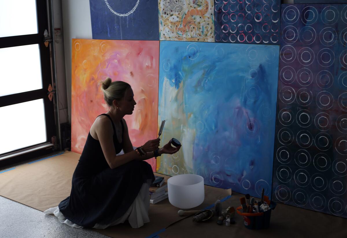 Artist Britt Michaelian uses a tuning fork on her paintings at her home.