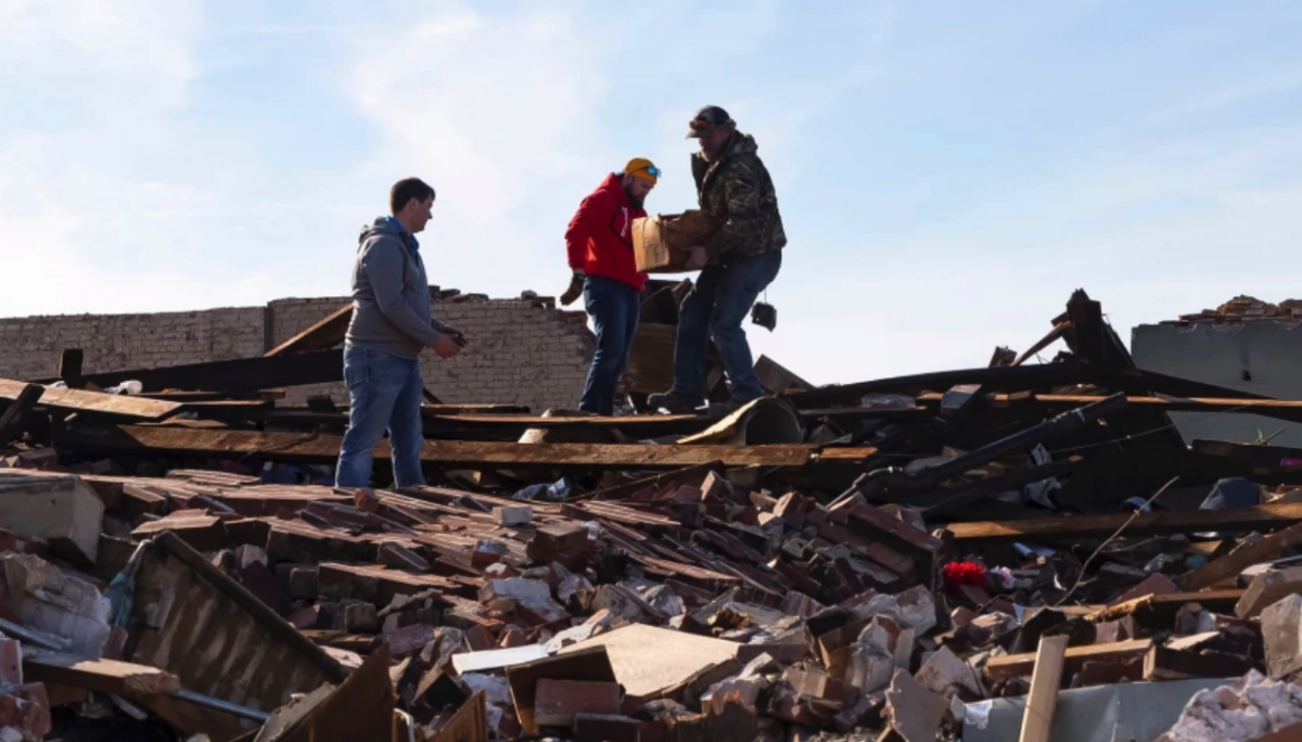 La gente observa los daños causados por un tornado en Mayfield, Kentucky