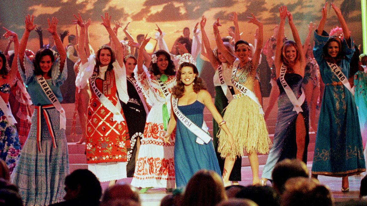 Miss Universe of 1996 Alicia Machado, center, of Venezuela dances with the 74 contestants of the Miss Universe pageant in Miami Beach.