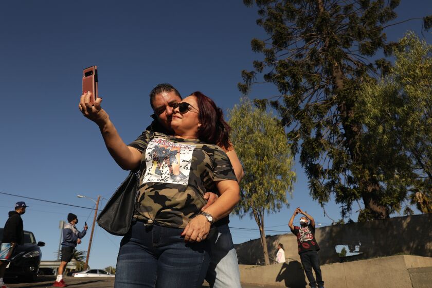 LOS ANGELES-CA-DECEMBER 31, 2020: Claudia Alva and her boyfriend Daniel Lopez traveled from Santa Fe, New Mexico to take a selfie in front of the world-famous pine tree in East Los Angeles known as "El Pino Famoso," which was featured in Taylor Hackford's 1993 film "Blood In Blood Out," after rumors it would be removed, on Thursday, December 31, 2020. (Christina House / Los Angeles Times)