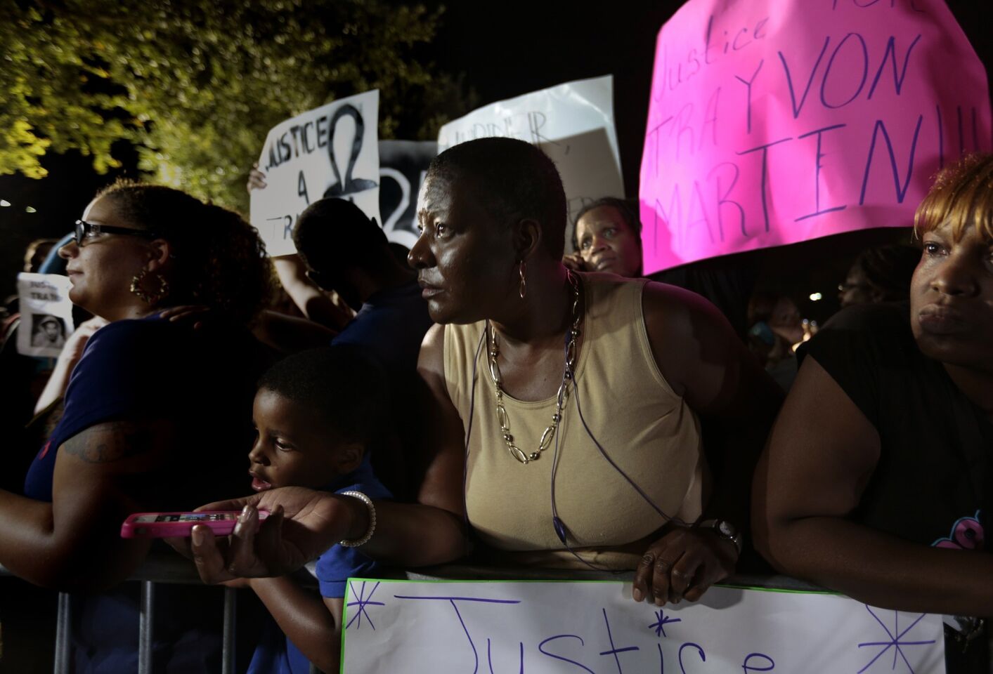 People gathered in Sanford, Fla., to support Trayvon Martin's family use smartphones to listen as the not-guilty verdict for George Zimmerman is read in court.