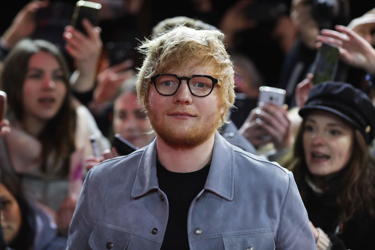 FILE - In this Friday, Feb. 23, 2018 file photo, singer-songwriter Ed Sheeran arrives for the screening of the film 'Songwriter' during the 68th edition of the International Film Festival Berlin, Berlinale, in Berlin, Germany. Sheeran is the new shirt sponsor for third-division English soccer club Ipswich, it was announced Thursday, May 6, 2021. The “Shape of You” singer signed a one-year deal to sponsor the men’s and women’s shirts next season. The 30-year-old musician grew up in the area and is a longtime Ipswich fan.(AP Photo/Markus Schreiber, file)