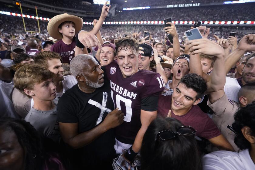 Texas A&M quarterback Zach Calzada (10) is surrounded by fans after the team's win over Alabama in an NCAA college football game Saturday, Oct. 9, 2021, in College Station, Texas. (AP Photo/Sam Craft)