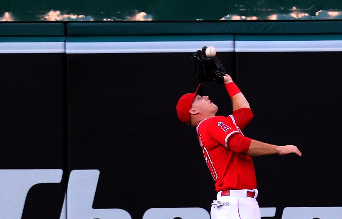 Angels center fielder Mike Trout makes a running catch on a long fly ball hit by Houston's Colby Rasmus in the third inning Tuesday night in Anaheim.